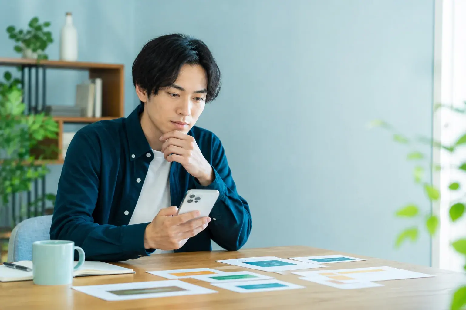 スマートフォンと複数の求人カードを見比べて条件を確認する求職者